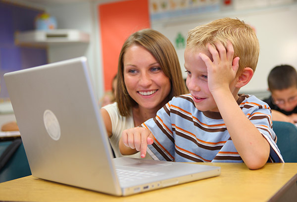 Photo of boy and teacher with compter